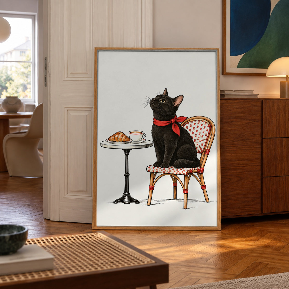 A sleek black cat in a red scarf perches on a bistro chair, waiting for coffee and croissants — poster in a styled room
