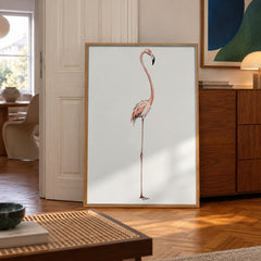 A graceful flamingo poised on one leg, rendered in soft watercolor pinks against a warm cream background — poster in a styled room