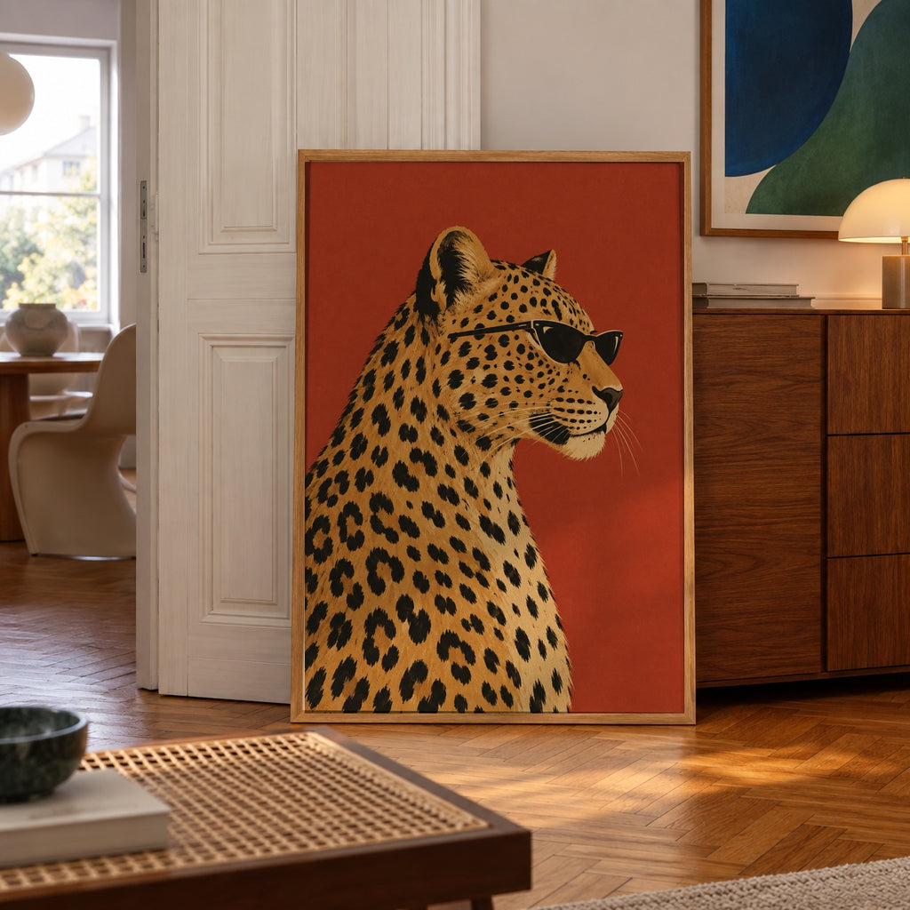 A stylish leopard strikes a pose in sleek black sunglasses against a bold terracotta backdrop — poster displayed in a styled room