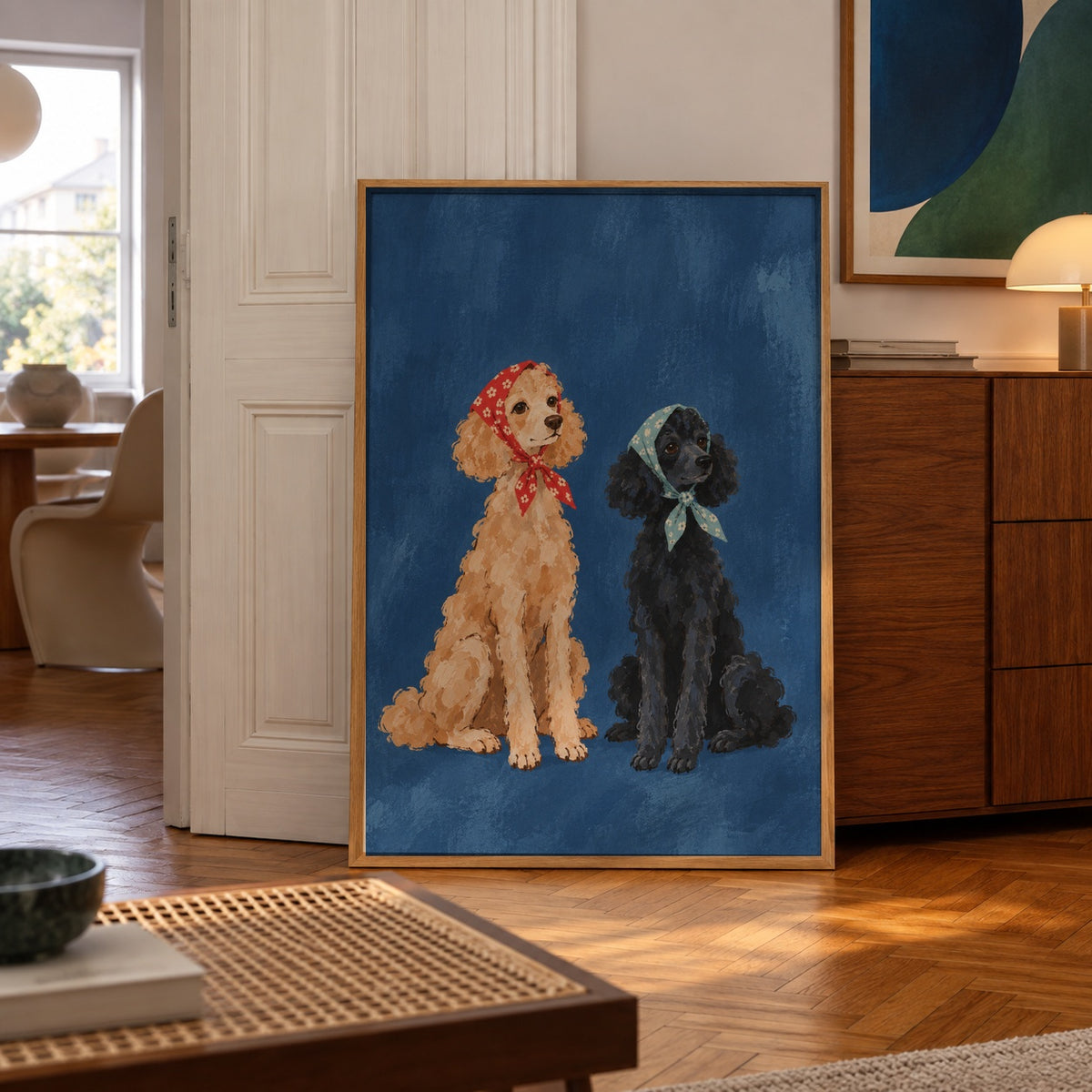 Two charming poodles, one apricot and one black, sit side by side wearing floral bandanas against a deep blue backdrop — poster displayed in a styled room