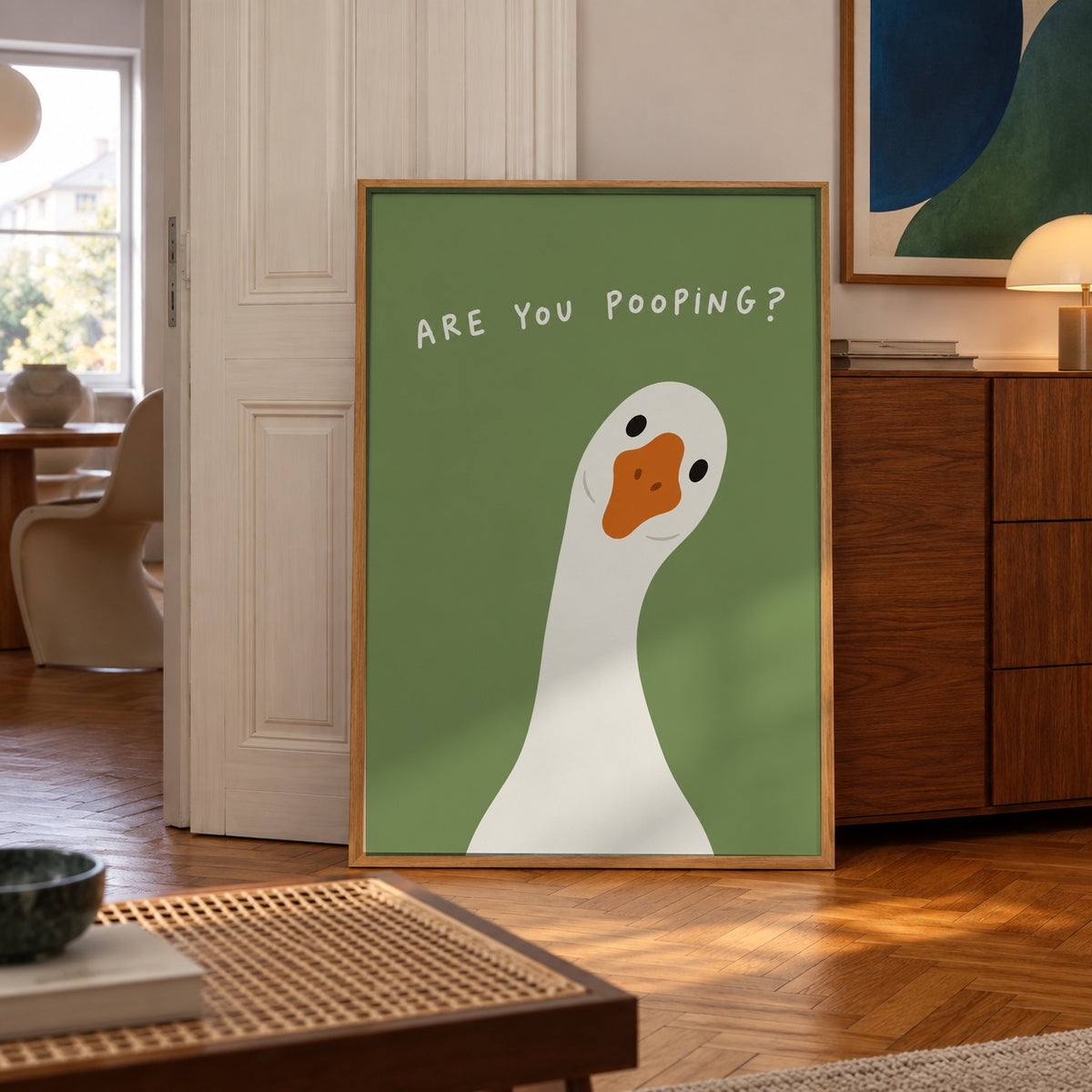 A cheeky goose pokes its head in to ask the one question nobody wants answered — poster displayed in a styled room