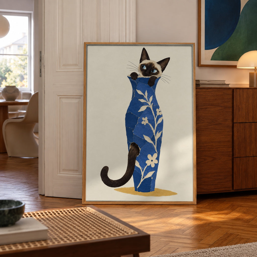 A curious Siamese cat peeks out from a collage-style blue floral vase, tail curling around the base — poster in a styled room