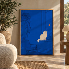 A cream-colored cat perches on a windowsill, captivated by a monarch butterfly fluttering just beyond the glass — wall art poster display