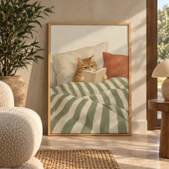 A cozy ginger tabby tucked into bed, reading a book beneath striped green sheets — wall art poster display